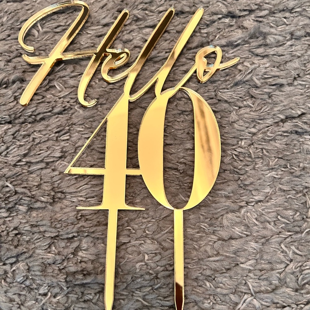 Mirror gold cake topper with the words “Hello 40”.